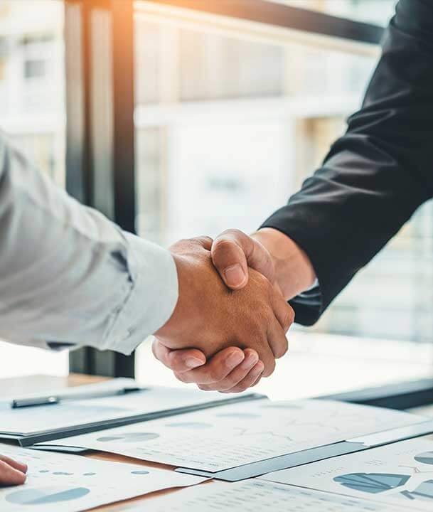 Apretón de manos sobre una mesa de trabajo